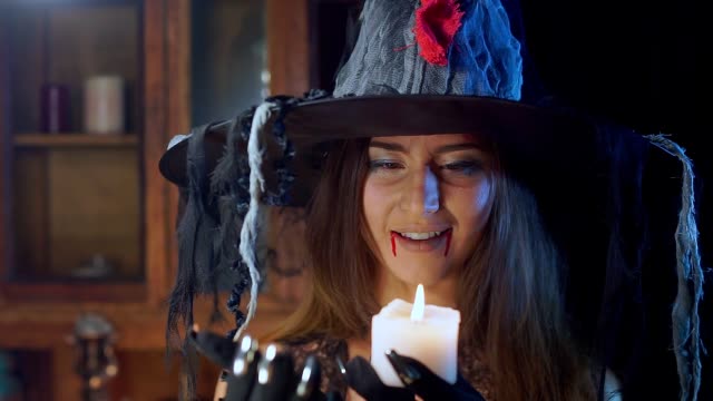 Halloween-Hexe-mit-Hut-hält-eine-Kerze-in-der-Hand.