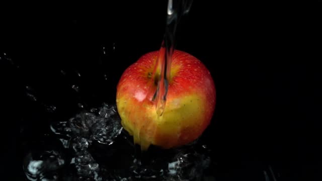 The-stream-of-water-flows-on-apples.-Slow-motion.