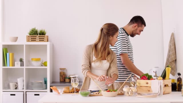 happy-couple-cooking-food-and-having-fun-at-home