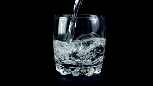 Wasser-in-einem-Glas-auf-einem-schwarzen-Hintergrund.-Slow-Motion.
