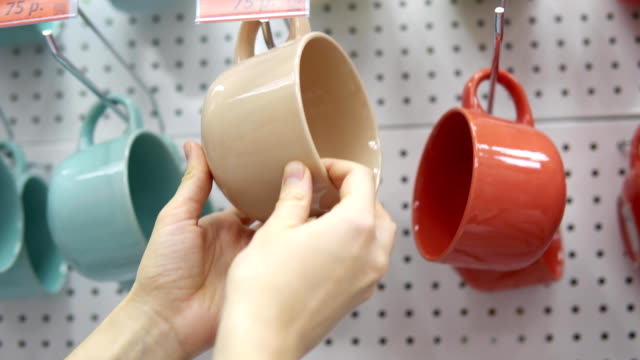Someone-picks-a-big-ceramic-cup-in-the-supermarket.