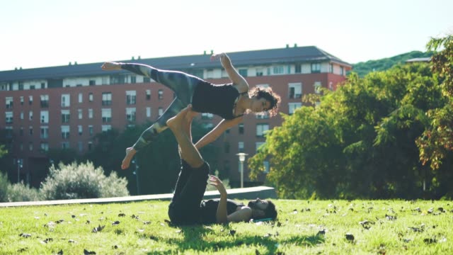 Hermosa-pareja-practicando-acro-yoga-en-la-mañana