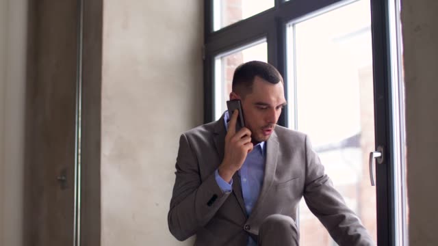 wütend-Geschäftsmann-auf-Smartphone-im-Büro-anrufen