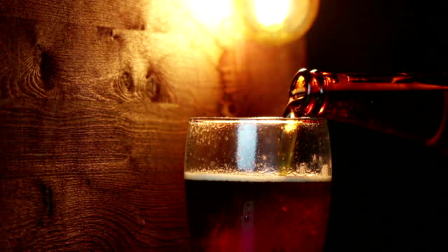 frisches-Bier-mit-Schaum-ins-Getränk-Pint-Glas-mit-Eis-gefrorenen-Tropfen-auf-gold-braune-Hintergrund,-Spaß-und-Ernährung-trinken