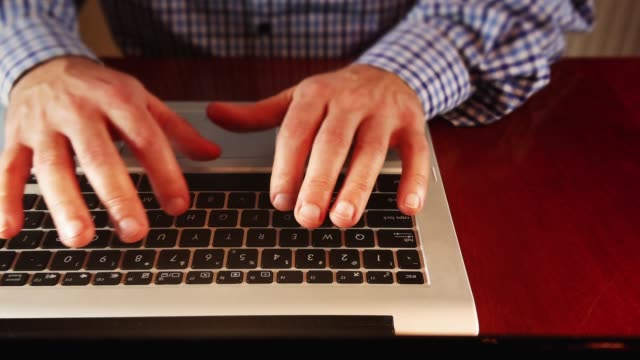 Mann-schreibt-auf-Laptop-Tastatur