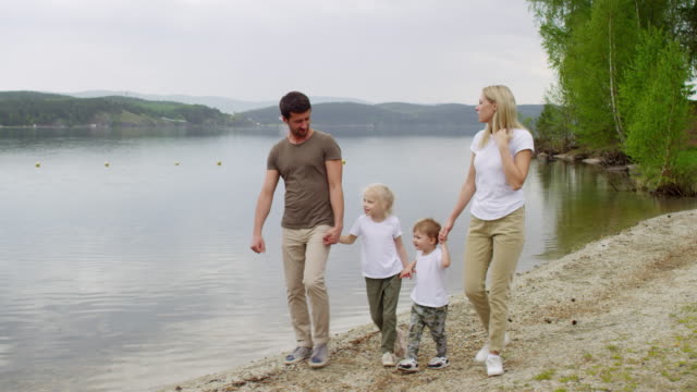 Family-Walking-by-the-Lake-and-Enjoying-Scenery