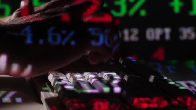 Close-Up-Typing-on-Keyboard-with-Stock-Exchange-Board-Projection