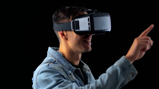 Portrait-of-Young-Man-using-VR-Glasses-on-Black-Background.-Male-Virtual-Reality-Console-Headset-Play-3D-Gaming-Innovation-Internet-Entertainment-Technology