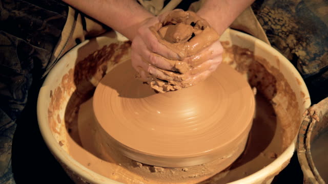 Ein-Töpfer-nutzt-beide-Hände,-um-Ton-in-eine-große-Vase-zu-werfen.