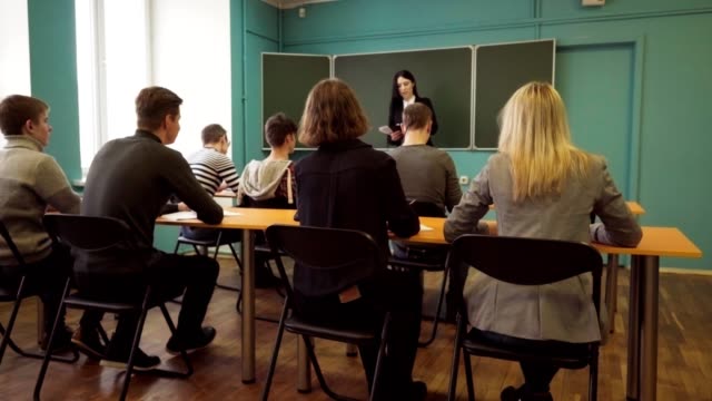 Frau-Dozent-spricht-mit-Schülern-im-Klassenzimmer