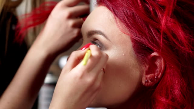 Make-up-Künstler-malt-Augenlider-an-den-Client-in-einem-Schönheitssalon