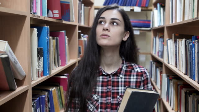 Chica-estudiante-busca-un-libro-en-la-biblioteca