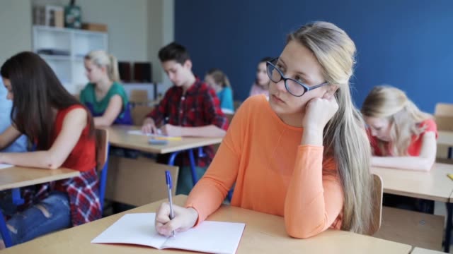 Gruppe-von-Studenten-mit-Notebooks-Test-in-der-Schule-schreiben