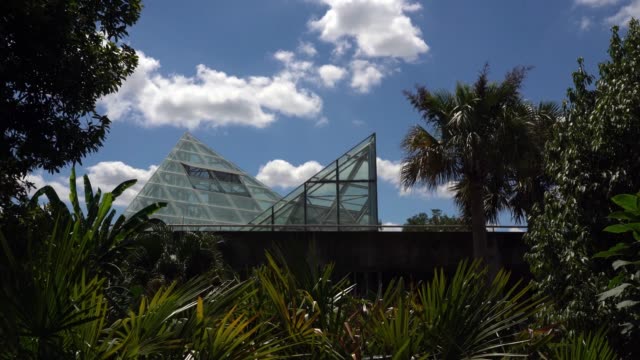 Panning-Video-of-Triangle-Shaped-Glass-Greenhouse-with-Blue-Sky-Background