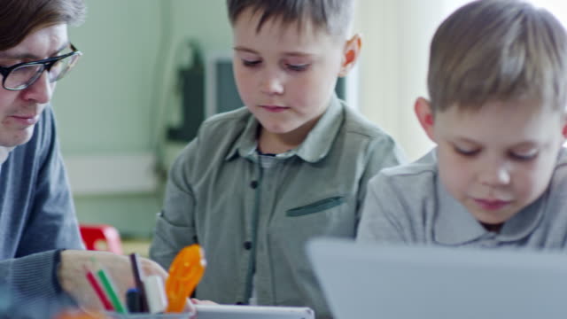 Schoolchildren-Talking-and-Using-Laptop-Computers