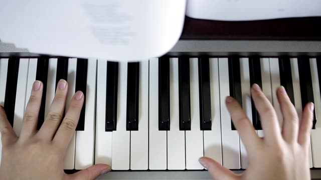 Teen-girl-plays-on-the-keyboard-of-the-digital-piano.-Close-up