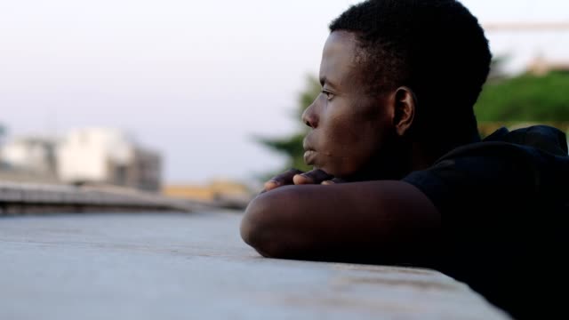 Tagträumen-nachdenklichen-jungen-amerikanischen-afrikanischen-Mann-erwägt-die-Stadt