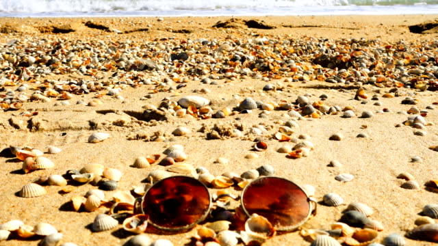 Sunglasses-on-the-sandy-beach.-Slow-motion.
