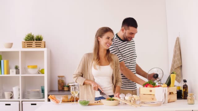 happy-couple-cooking-food-at-home-kitchen