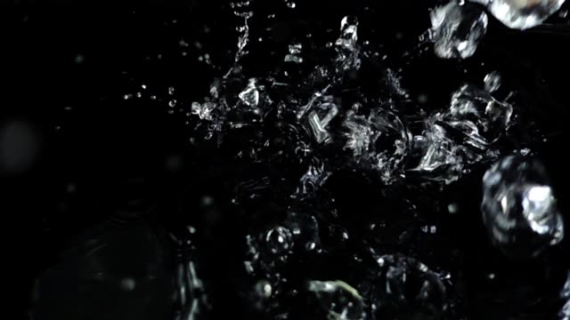 Fallen-von-Eiswürfeln-auf-einem-schwarzen-Hintergrund.-Slow-Motion.
