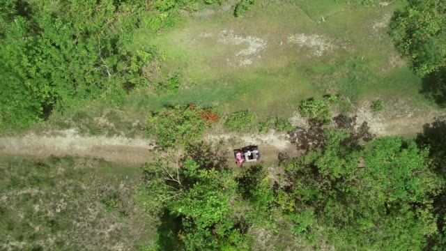 Aerial-view-two-quadricycles-doing-trail-next-Chocolate-Hills-Complex,-Batuan.