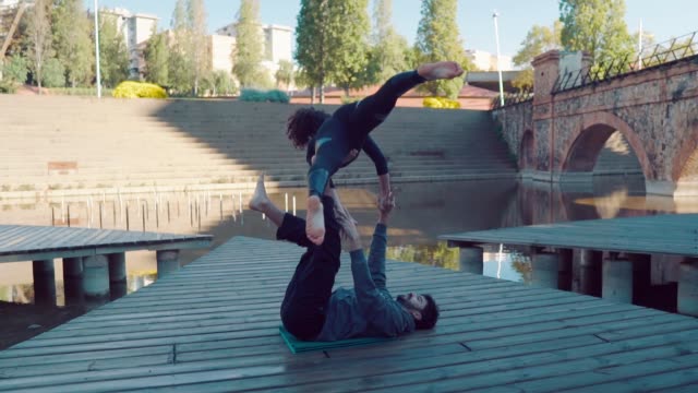 Hermosa-pareja-practicando-acro-yoga-en-la-mañana