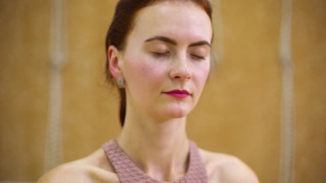 Mujer-joven-medita-mientras-practicaba-yoga-en-clase-de-fitness