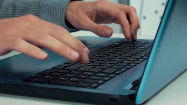 Las-manos-masculinas-están-escribiendo-texto-en-un-ordenador-portátil.-Oficina,-mesa-blanca,-de-cerca