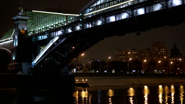 Blick-vom-Deck-des-Schiffes,-die-schwimmt-auf-dem-Fluss,-entlang-der-Uferpromenade-für-den-Urlaub-eingerichtet.-Schwimmen-unter-einer-schönen-Brücke.