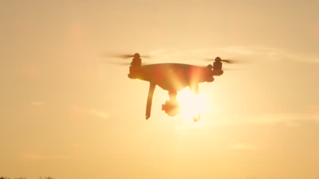 SLOW-MOTION-enge-UP-LENS-FLARE-SILHOUETTE-Filming-Drohne-fliegt-über-die-untergehende-Sonne