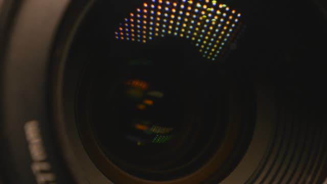 Video-camera-lens,-showing-zoom-and-glare,-turns,-close-up
