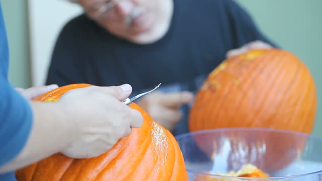 Two-men-carving-Halloween-pumpkins