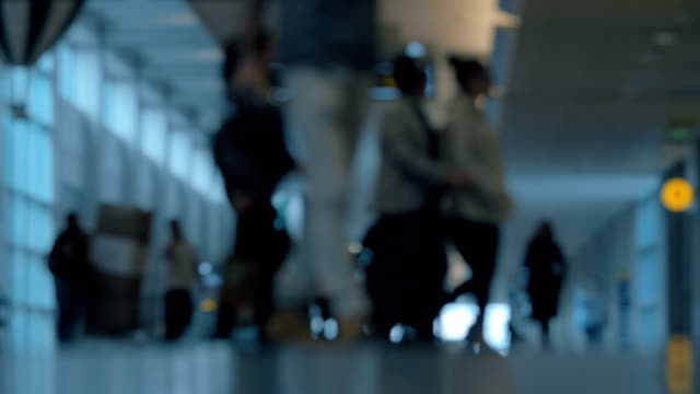 People-with-baggage-in-airport-hall,-defocus