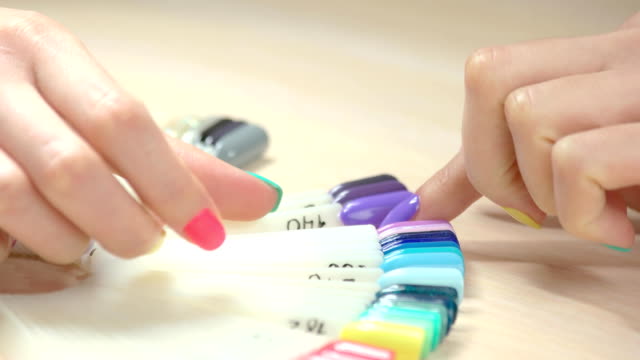 Woman-choosing-purple-nail-sample.