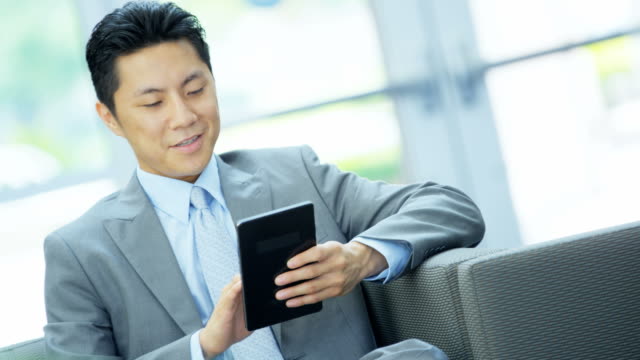 Asian-Chinese-businessman-using-touch-screen-mini-tablet