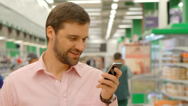 Male-customer-using-mobile-phone-in-shopping-mall