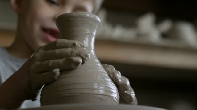 Fröhliche-Junge-Vase-in-Keramik-Klasse