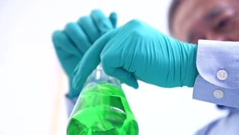 Scientists-working-in-lab-portrait.-Senior-chinese-male-scientist-working-in-lab,-stirring-a-flak-portrait-with-copy-space.