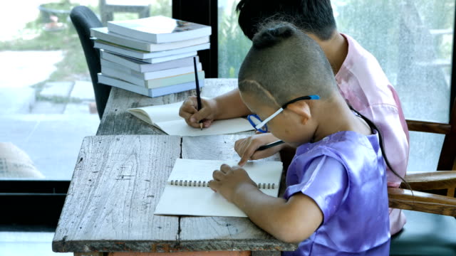 Asiatische-junge-zwei-Leute-mit-dem-Schreiben-von-Hausaufgaben.-Bildungskonzept