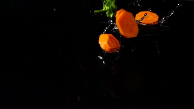 Falling-of-segments-of-carrots,-parsley-and-fennel.-Slow-motion.