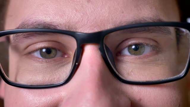 Close-up-eyes-of-caucasian-male-in-glasses-looking-at-camera-and-enjoying