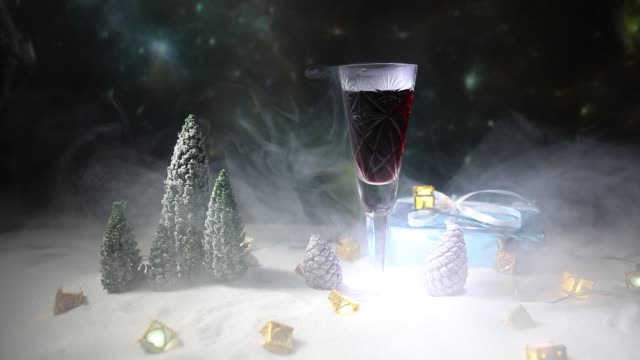 Glas-Wein-mit-Weihnachtsdekoration.-Rotwein-in-Kristall-Glas-auf-Schnee-mit-kreativen-Neujahr-Kunstwerk.-Textfreiraum