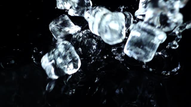 Falling-of-cubes-of-ice-on-a-black-background.-Slow-motion.