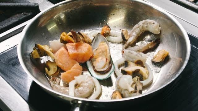 Fragrant-prawns,-mussels-and-fish-are-fried-in-a-saucepan-in-a-frying-pan-in-slow-motion-in-4k-resolution