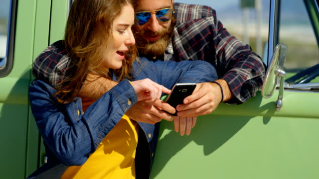 Cute-couple-discussing-on-mobile-phone-on-a-sunny-day-4k