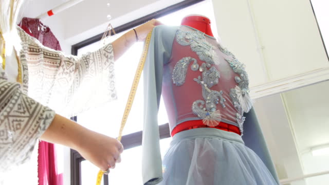 Fashion-designer-measuring-dress-on-dressmakers-model-4k