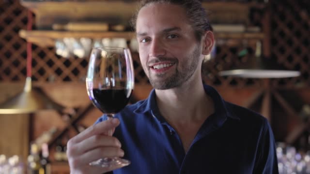 Hombre-bebiendo-vino-tinto-de-cristal-en-el-restaurante-de-la-bodega