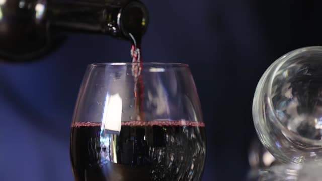 Wine.-Closeup-Of-Red-Wine-Pouring-Into-Glass-From-Bottle