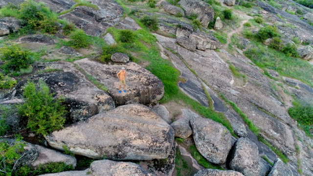 Hombre-joven-caminando-y-de-pie-sobre-las-rocas