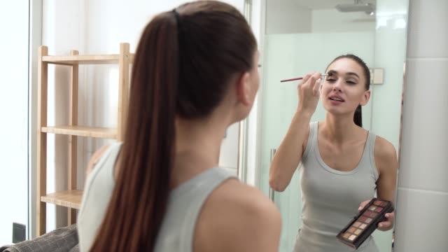 Make-up.-Frau-Anwendung-Lidschatten-und-Spiegel-betrachten